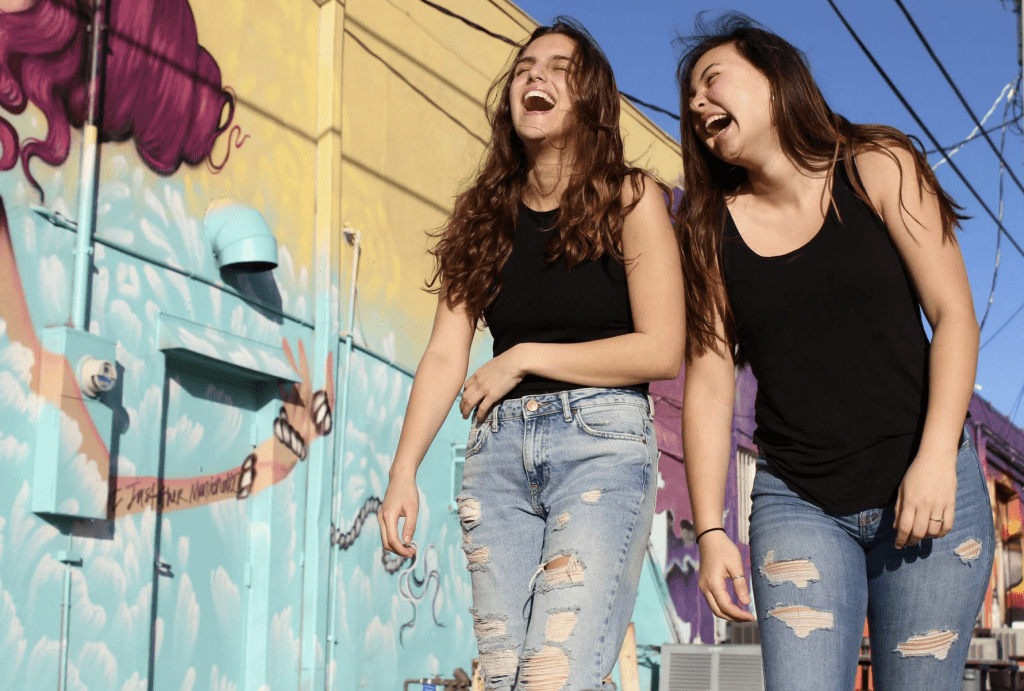 Two ladies laughing using friendship to manage stress
